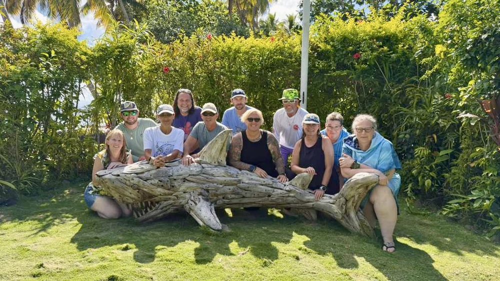 Me and a group of students posing with a driftwood shark sculpture in Fiji.